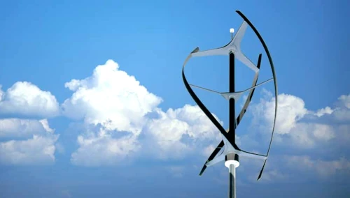Éolienne moderne sous ciel bleu et nuages.